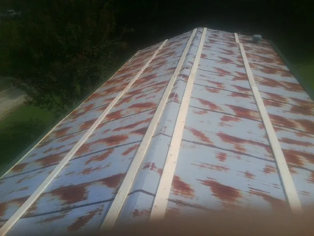 Rusted metal roof panels with new wood purlins before replacement — Storm Damage Roof Repair in Middle Village by Roofing Brothers