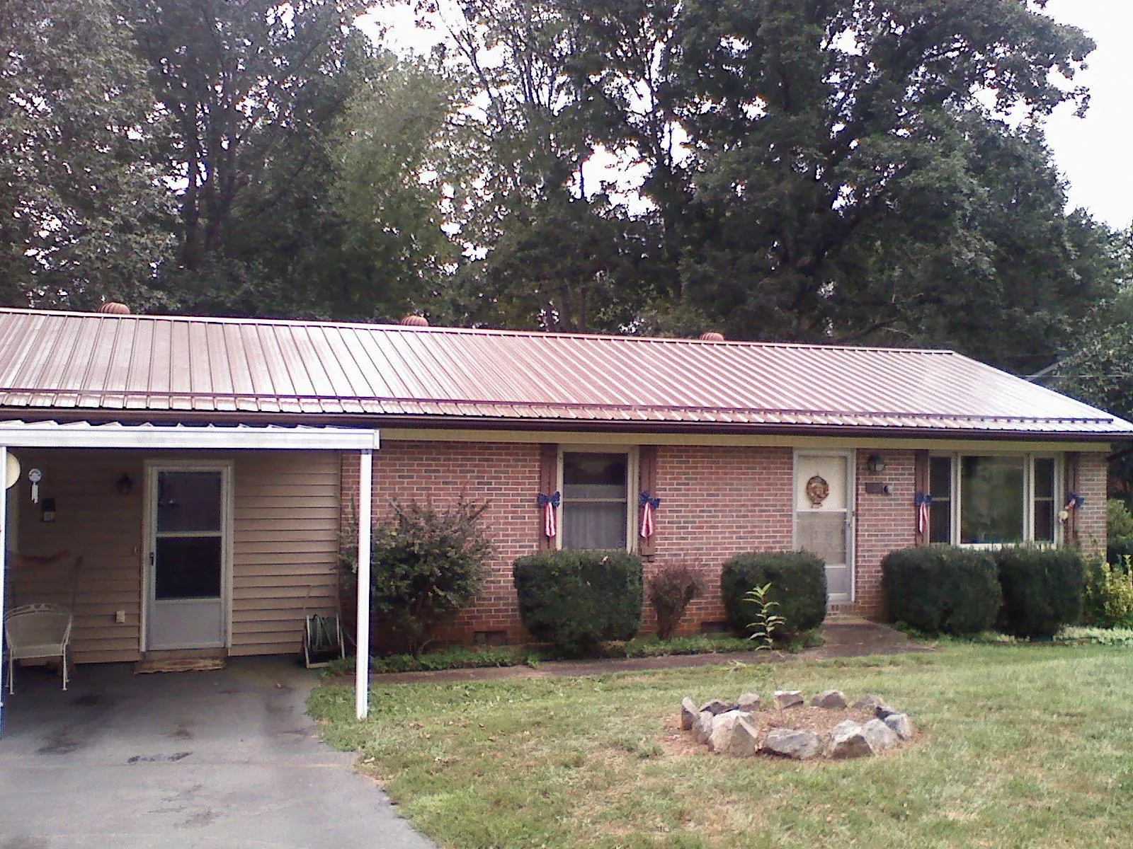 Bronze metal roof and carport on a brick ranch home — Roof Repair work by our crew in Middle Village