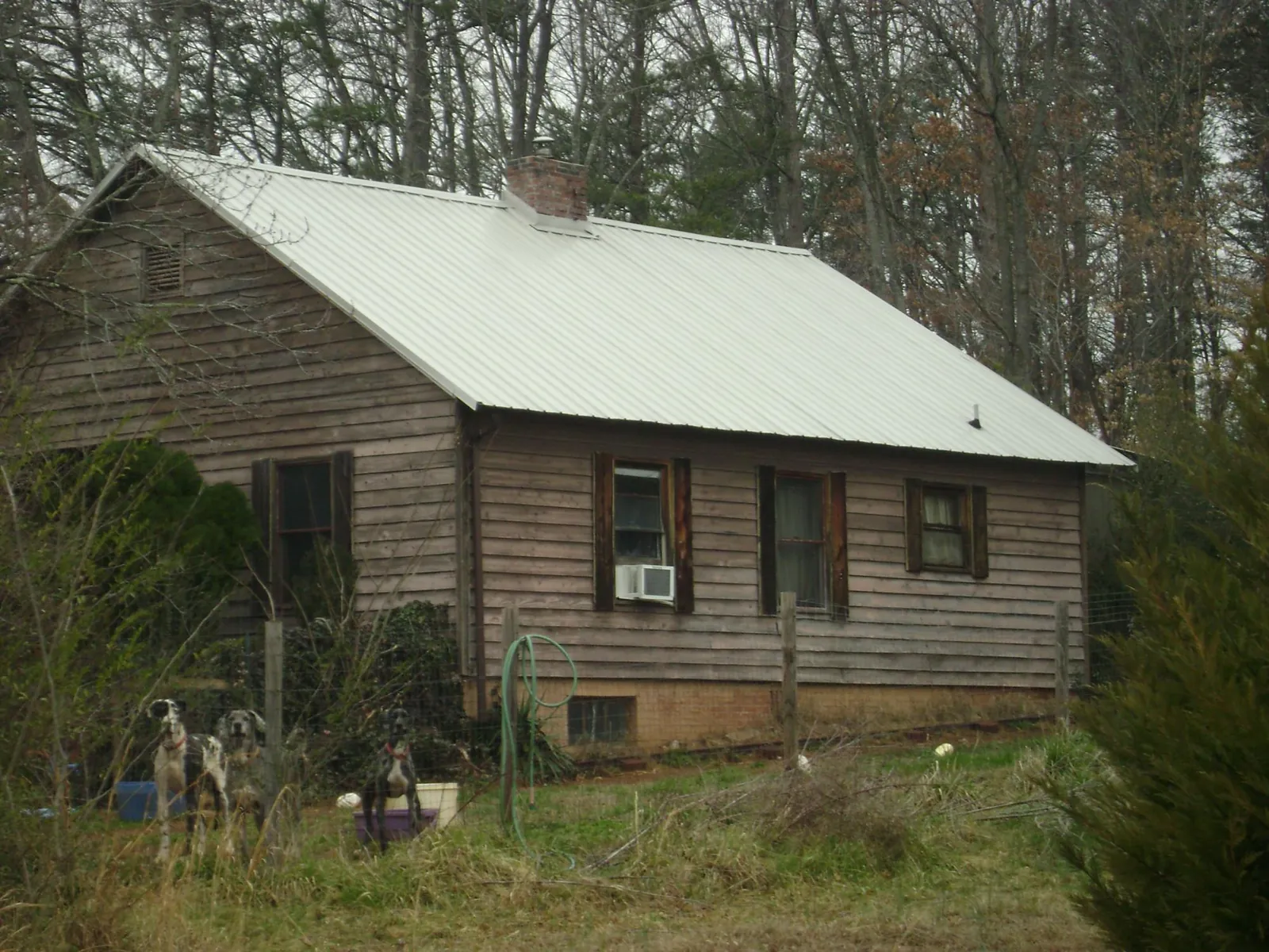 White metal roof on an old wood sided farmhouse, from a Metal Roof Installation job in Middle Village